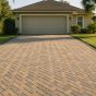 Paver driveway ideas in action: a herringbone paver driveway with a charcoal soldier-course border leading to a stucco Jacksonville home